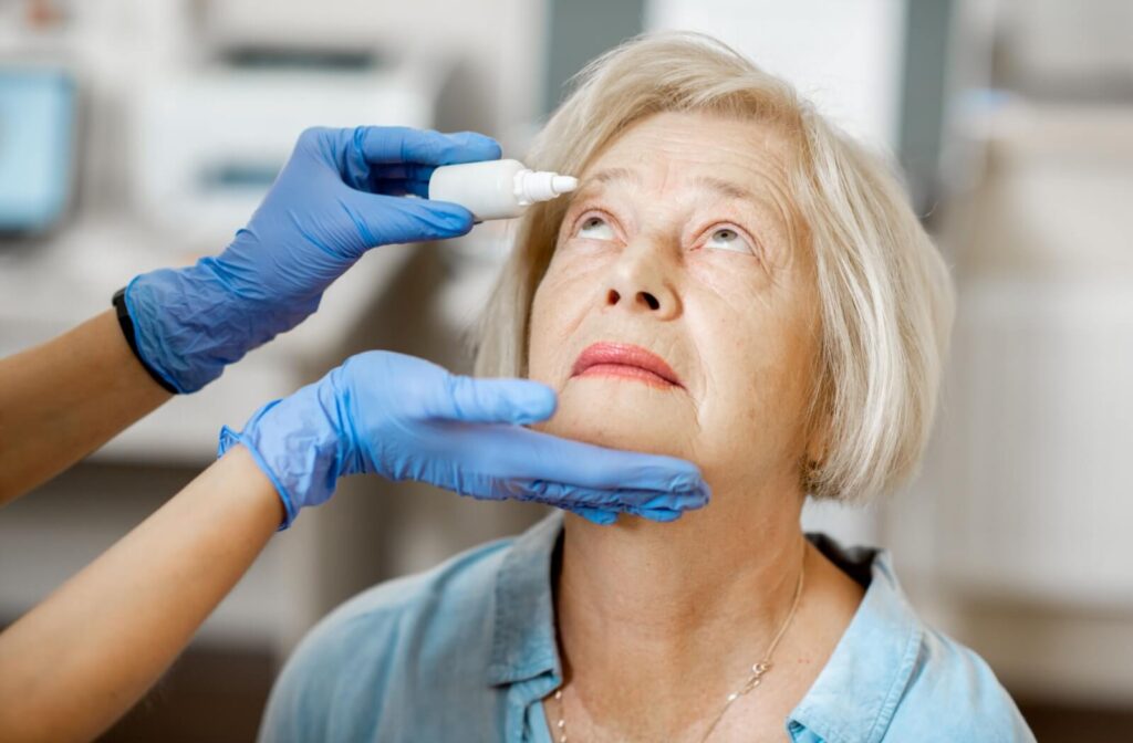 A person takes off their glasses and squints to try and see clearly.