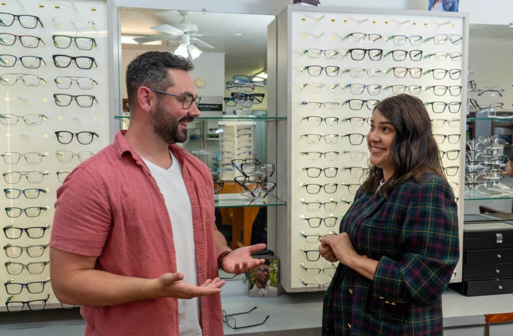 Optician helping customer choose new eyeglasses.