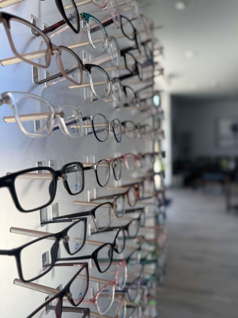 A display wall of eyeglass frames in various shapes and colours inside Bethany Eye Care